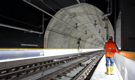 a worker standing next to a large underground tunnel